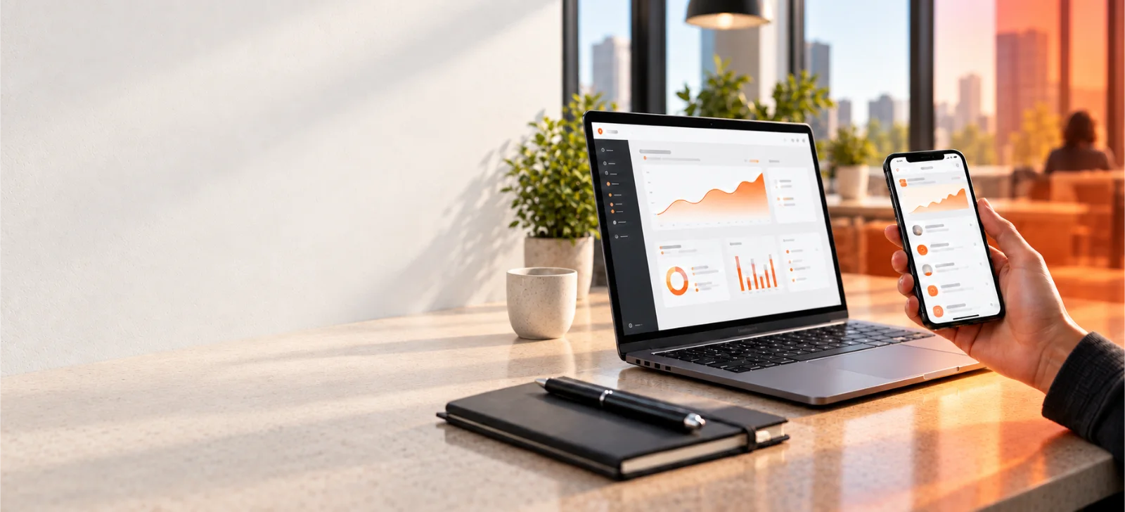 Notebook e celular com sistemas de gestão conectados.